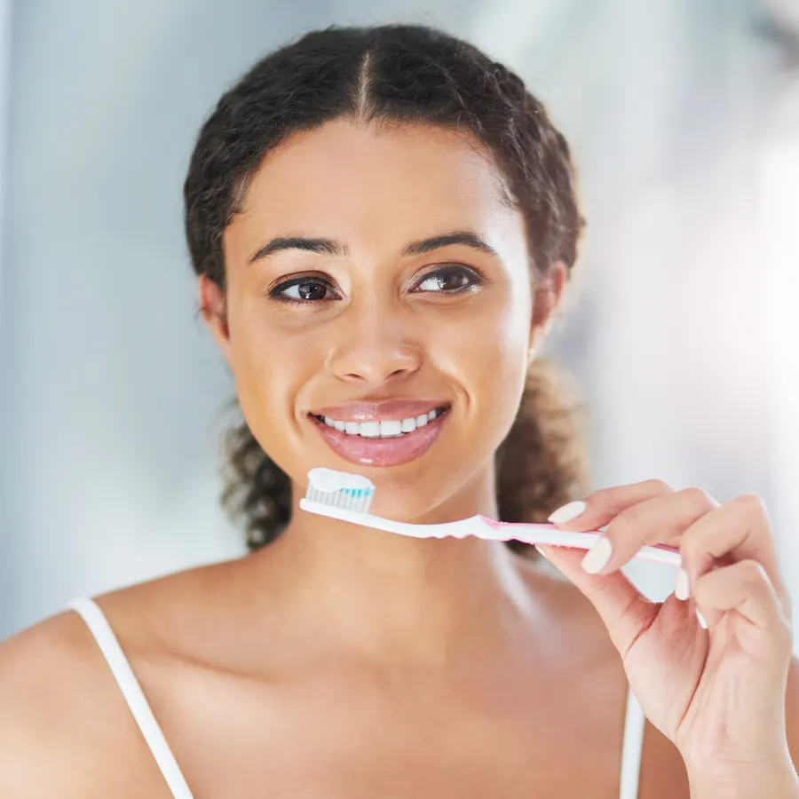 Woman caring for her teeth and gums at home